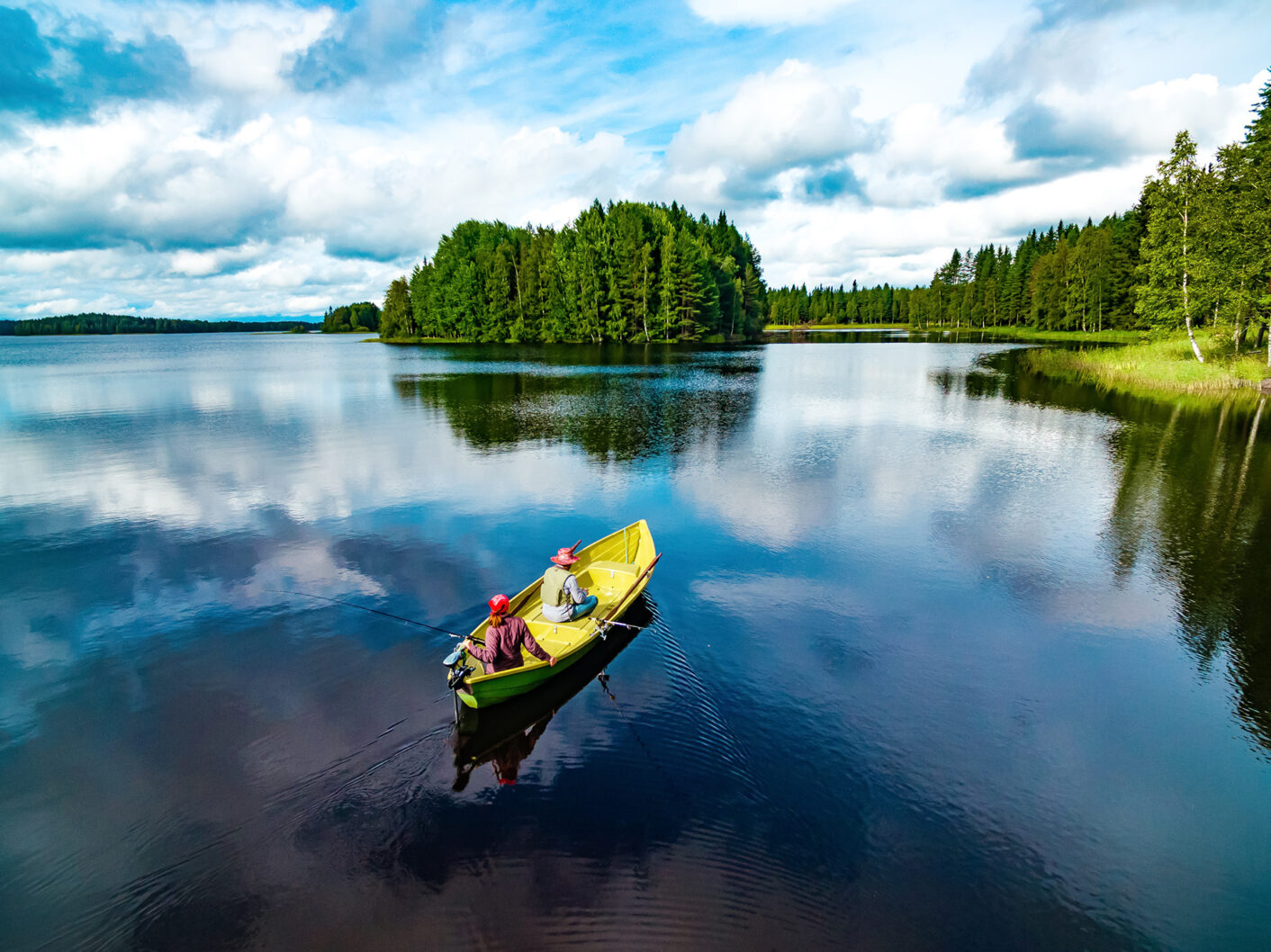 kaksi onkijaa keltaisessa veneessä, järvimaisemassa kesällä