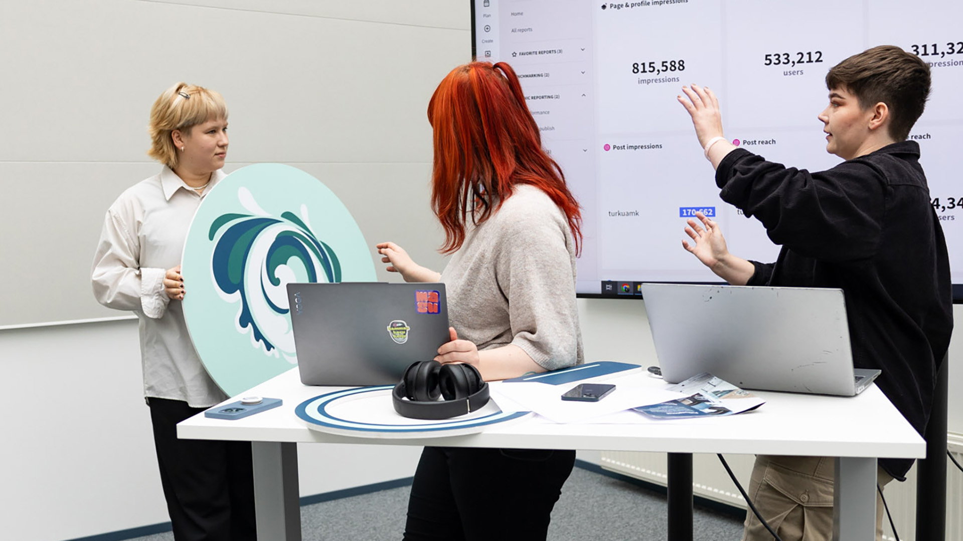 kolme opiskelijaa yhdessä pöydän ääressä