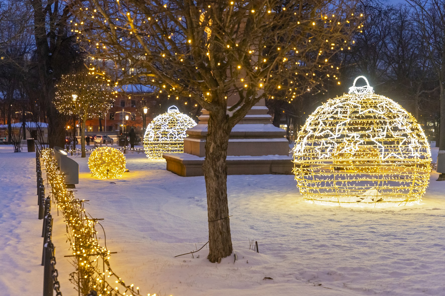 valotaideteoksia ja valaistuja puita lumisessa puistossa