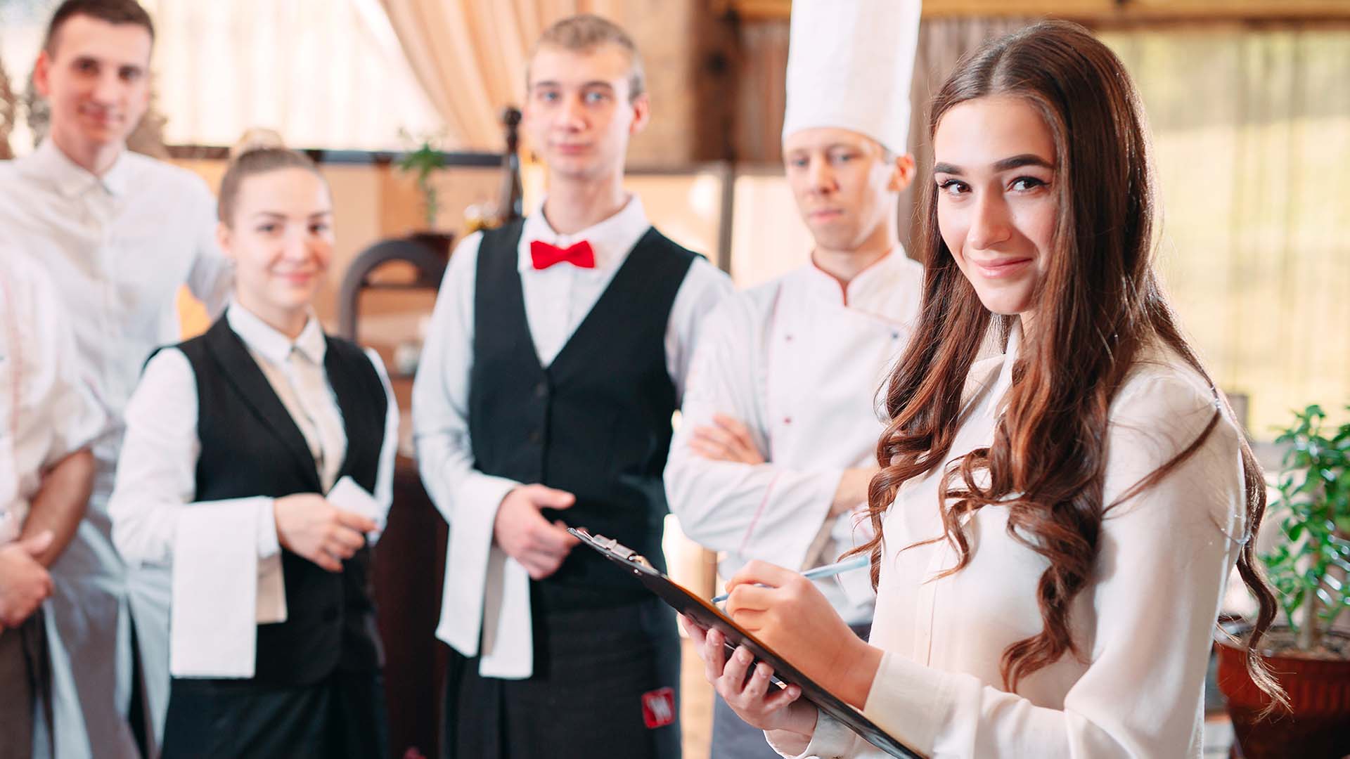 Ravintolatyöntekijöitä, esihenkilö etualalla