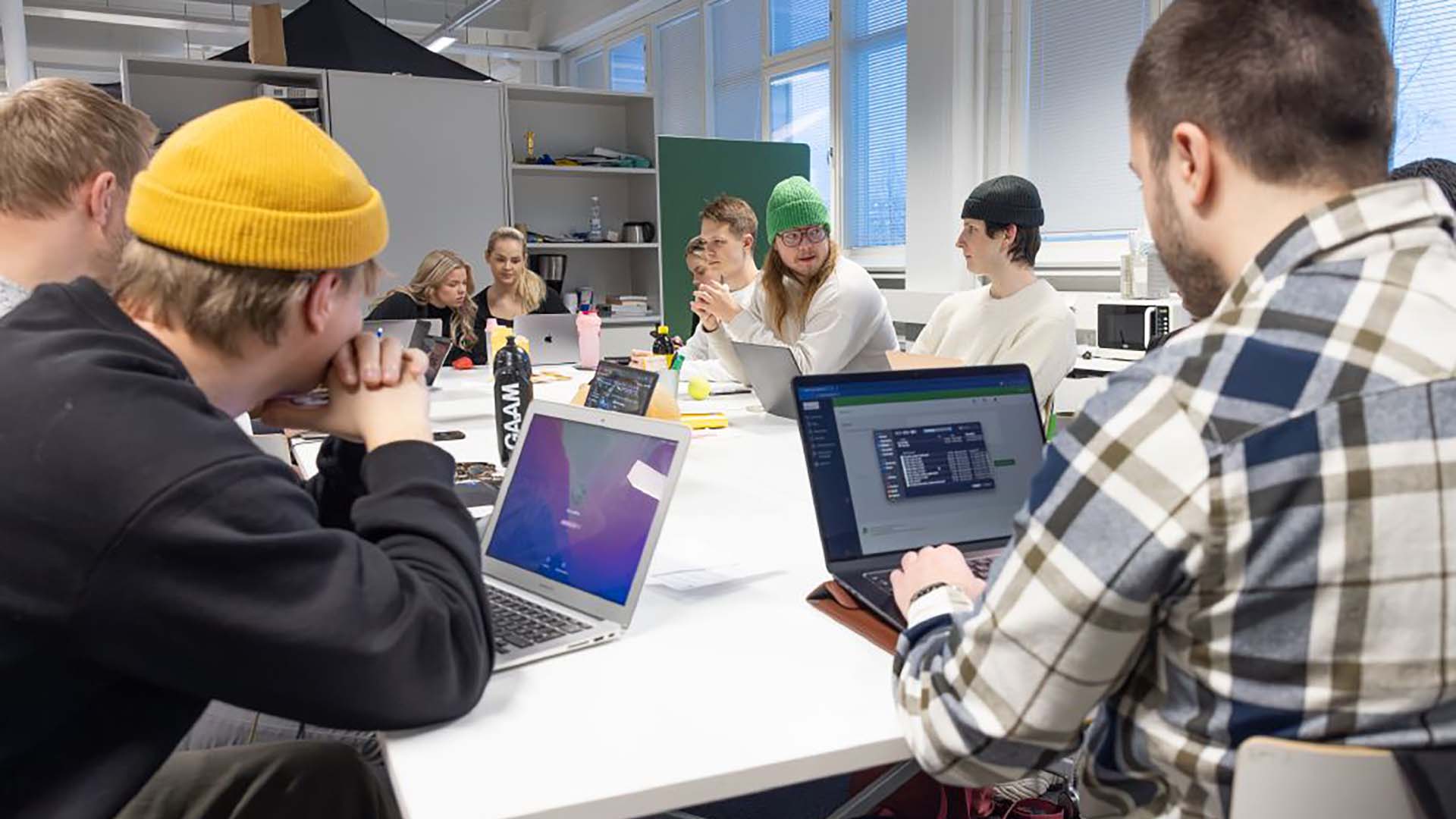 Ryhmä nuoria opiskelemassa pöydän ääressä