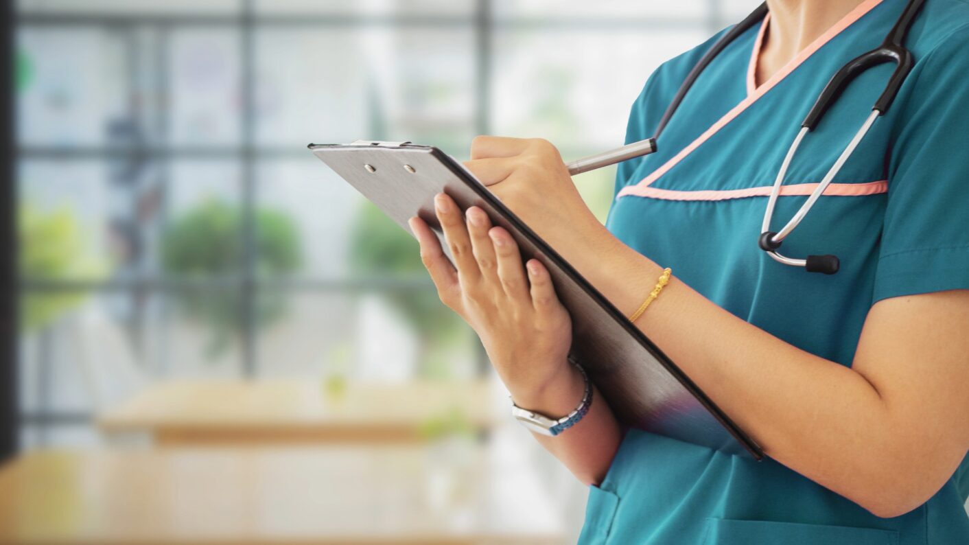 Sosiaali- ja terveysalan työntekijä kirjaa muistiinpanoja.