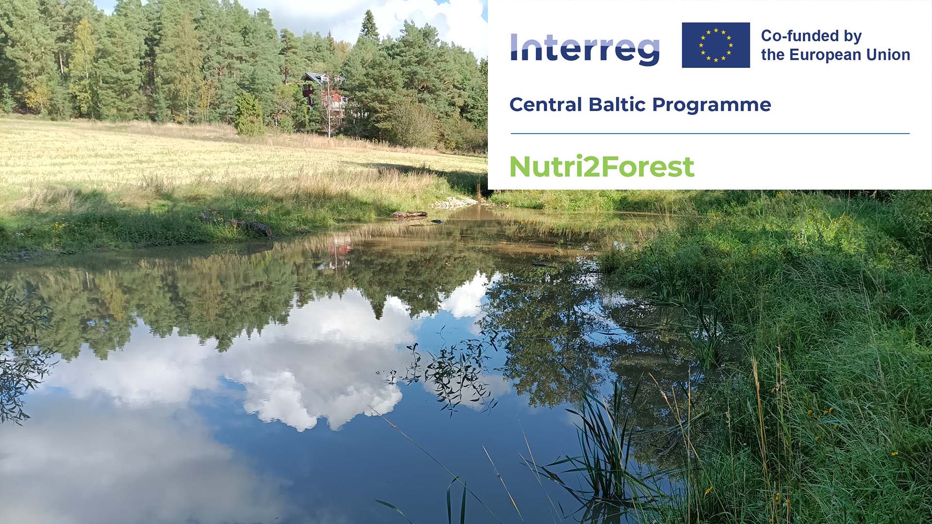 A clear-water pond, reflecting the sky and clouds. On top of the picture are the donor logos