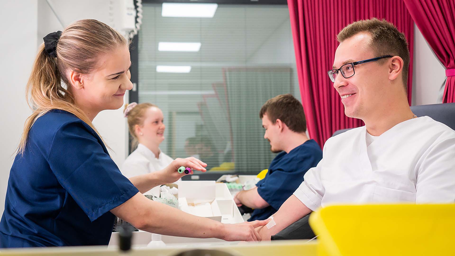 Asiakkaita ja näytteenottajia laboratoriossa